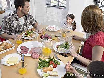 Family Having Meal At Dining Table