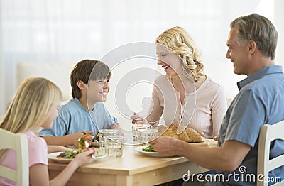 Family Having Meal At Dining Table