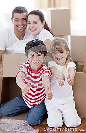 Family moving house with boxes and thumbs up