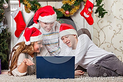 Family with notebook near Christmas tree.