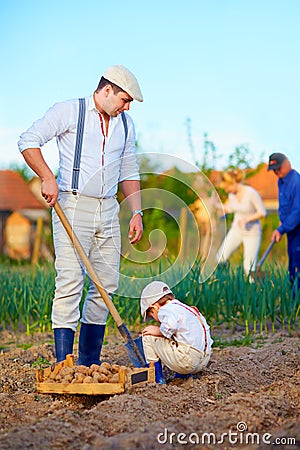 Family planting potatoes in vegetable garden