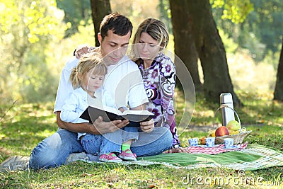 Family read the Bible in nature