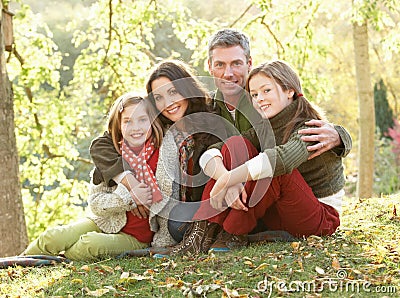 Family Relaxing Outdoors In Autumn Landscape