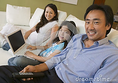 Family Relaxing on sofa in Living Room daughter with Laptop portrait
