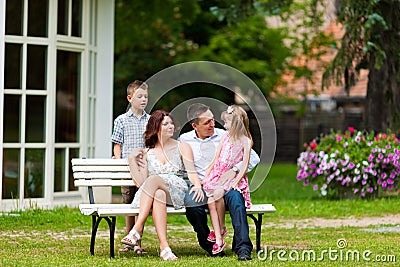 Family sitting in front of their home