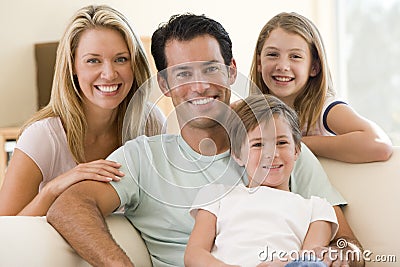 Family sitting in living room smiling