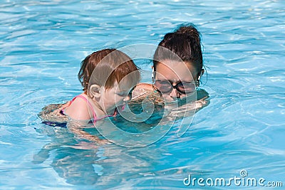 Family in swimming pool playing