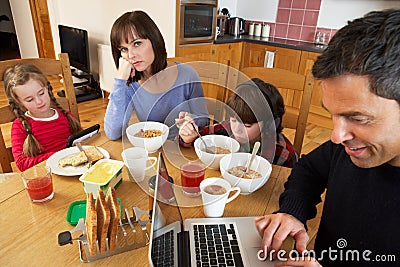 Family Using Gadgets Whilst Eating Breakfast