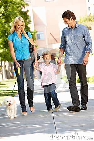 Family walking dog in city street