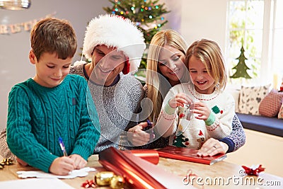 Family Wrapping Christmas Gifts At Home