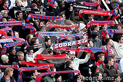 Fans waving scarfs at football game