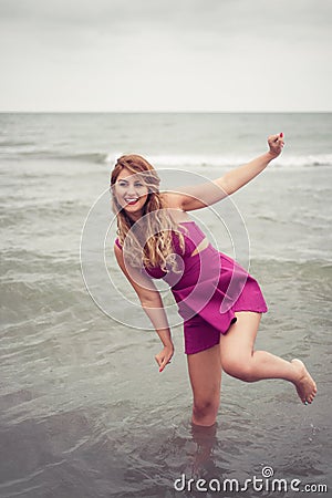 Fashion blonde at the beach sea side posing shoe-less in water