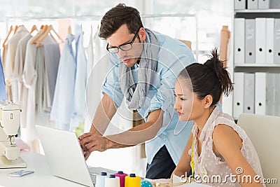 Fashion designers using laptop in studio