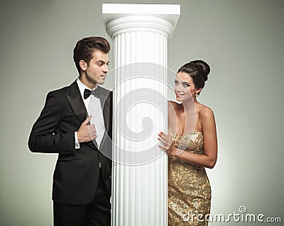 Fashion elegant couple looking at each other near column