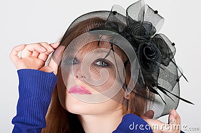 Fashion girl in a big hat in the studio