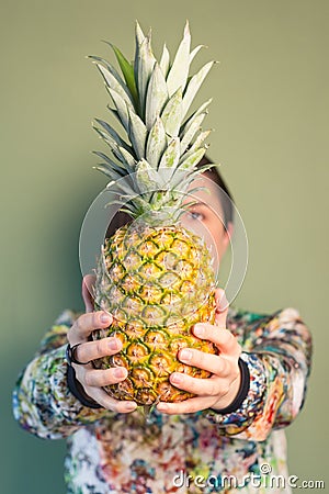 Fashion girl holding pineapple in front of face