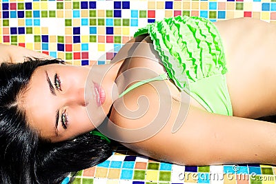 Fashion model with green eyes laying in bikini