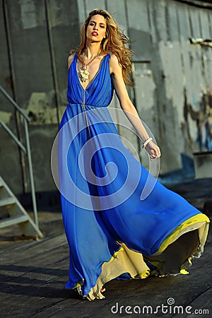 Fashion model posing sexy, wearing long blue evening dress