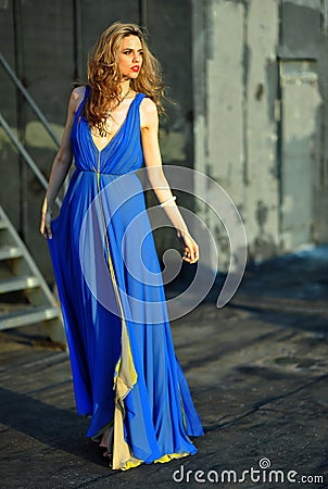 Fashion model posing sexy, wearing long blue evening dress