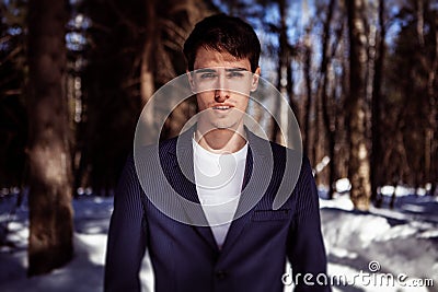 Fashion portrait of a man in snow forest in vogue style
