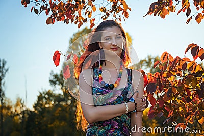 Fashion portrait of young hippie woman walking in autumn field. Romantic sunny evening