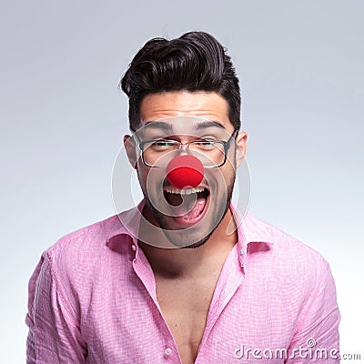 Fashion young man shouts with a red nose