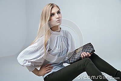 Fashionable woman with a bag in light background