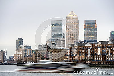 Fast boat on Thames, London; Canary Wharf at back