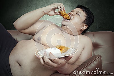 Fat man eats fast food