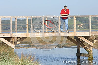 Fat man resting over bridge looking to landscape