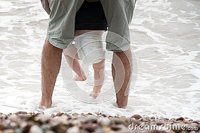 Father and baby sea wading