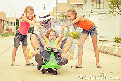 Father and children playing near a house