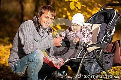 Father and daughter in buggy at autumn park