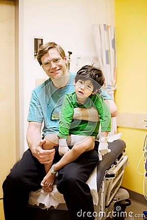 Father holding his sick disabled son at hospital