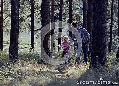 Father learning his son to ride on bicycle outside