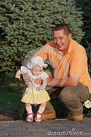 Father and little daughter on background of spruce