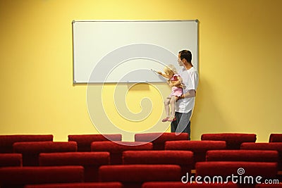 Father and little girl in empty presentation hall