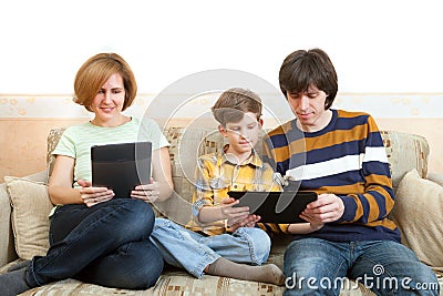 Father, mother and son sit with electronic devices