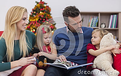 Father reading a book for his girls