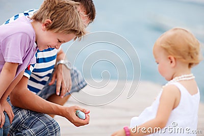 Father showing his kids a fish.