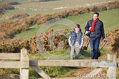 Father And Son With Dog Walking Along Coastal Path