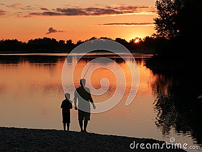 Father and son fishing at sunset