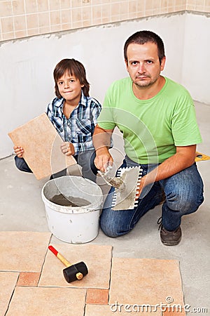 Father and son laying floor tiles together