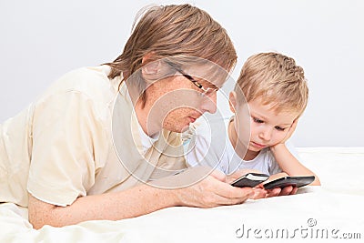 Father and son with mobile phones at home