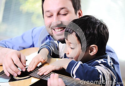 Father and son playing guitar