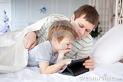 Father and son playing on tablet