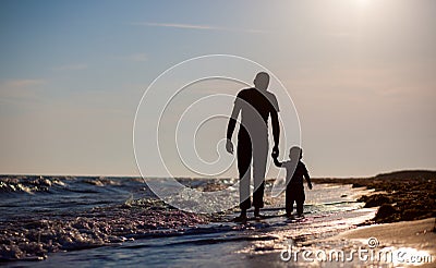 Father and son to the sea at sunset