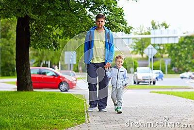 Father and son walking on city street