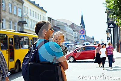 Father, son walking through crowded city street