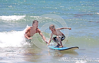 Father teaching his young son to surf